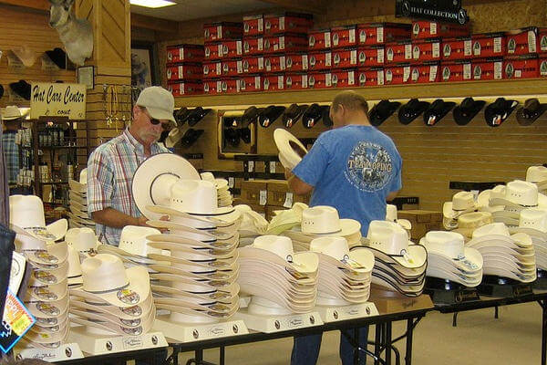 Männer schauen sich Cowboyhüte im Geschäft an