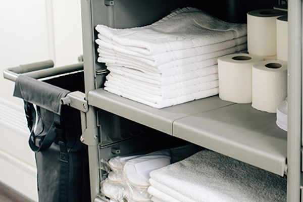 Reinigungswagen im Hotel mit Handtüchern und Toilettenpapier
